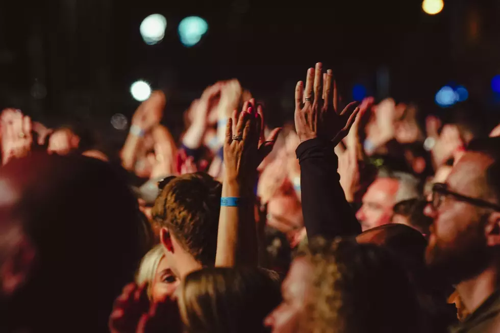 a crowd of people at a concert with their hands up