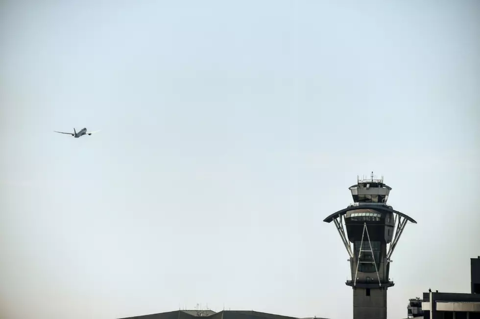air traffic control tower with a plane flying in on the left