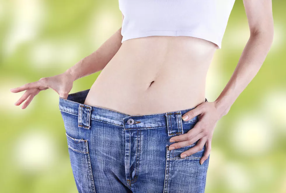 Slim woman shows her weight loss by wearing jeans