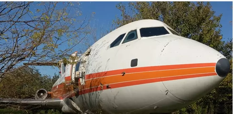 There is a private jet left abandoned off of a highway in Illinois.
