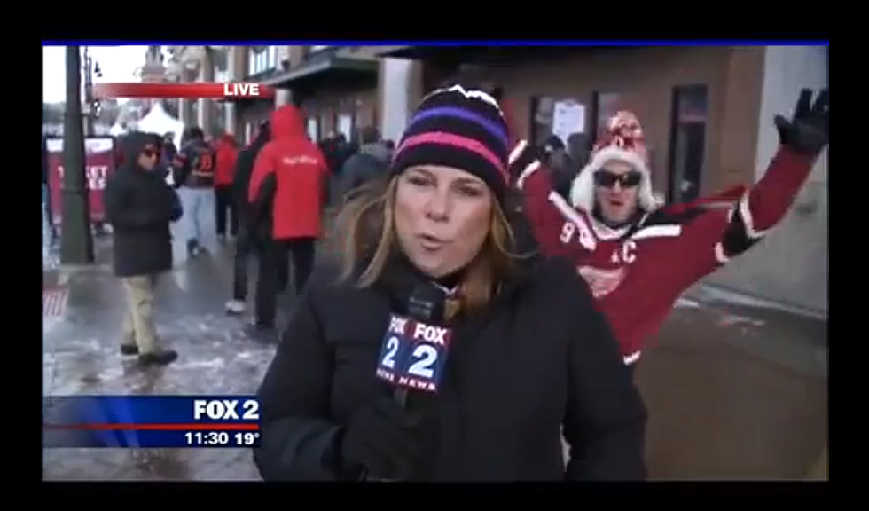 A Man Trying to Photobomb a News Reporter, Wipes Out on Ice