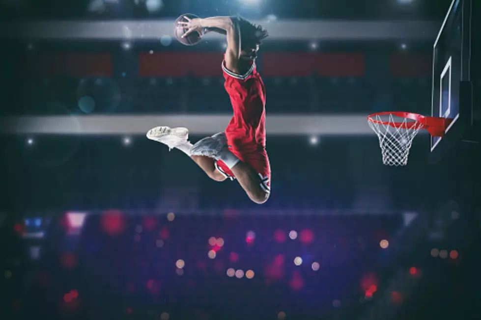 Basketball player slams dunk the ball to the basket