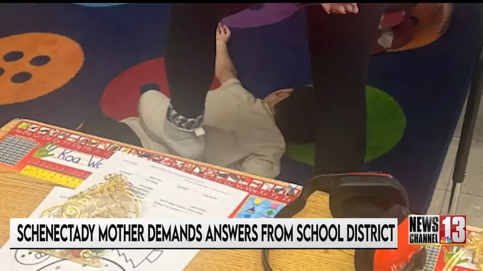 The photo shows a young boy, face down, with an adult's foot on his back. Photo: Screengrab from New Channel 13