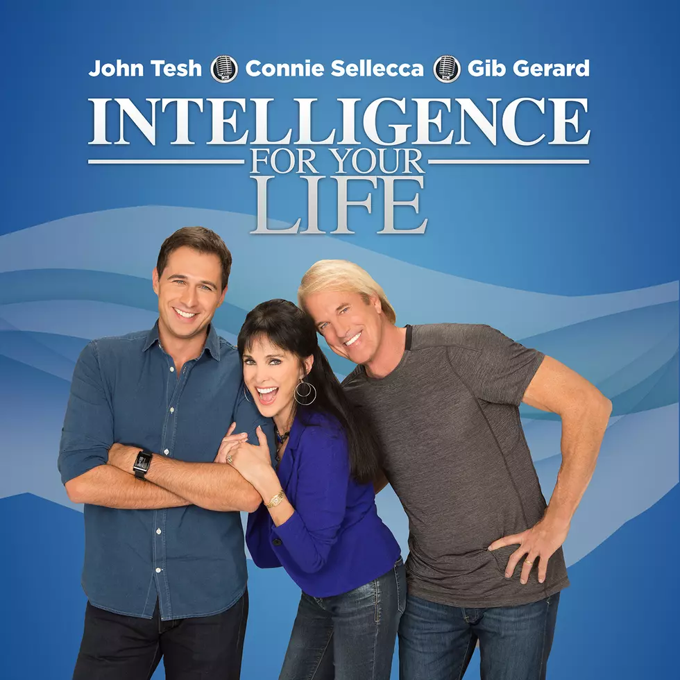 two men, one woman, standing next to eachother smiling. blue background.
