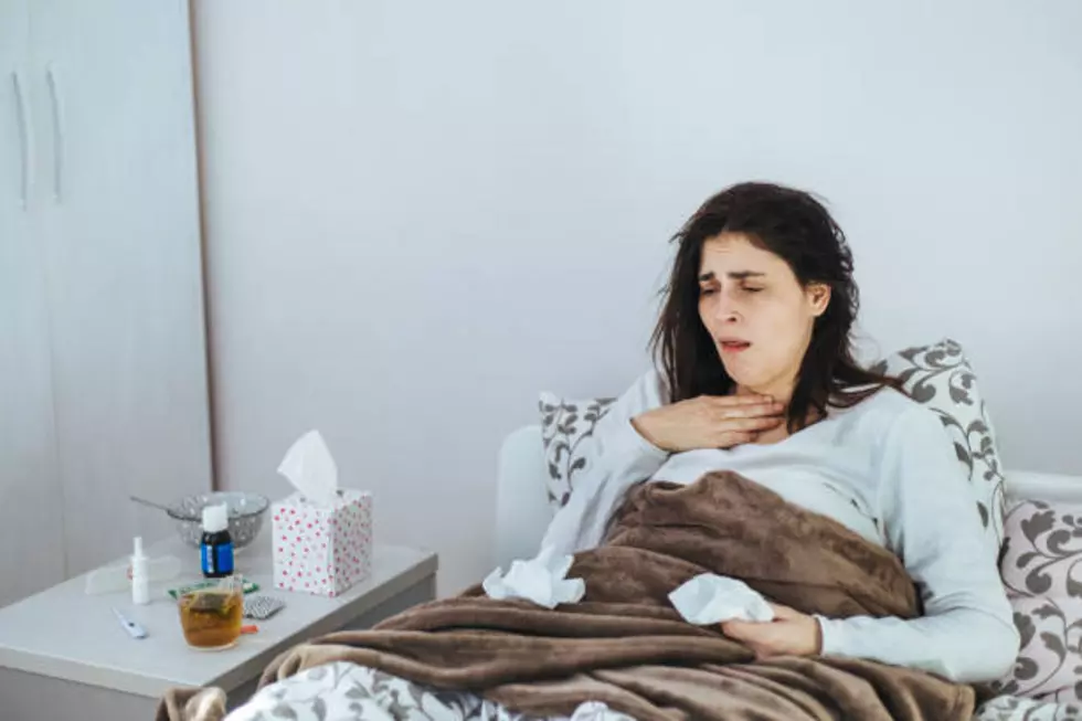 Woman Suffering From Cold Lying In Bed With Tissue