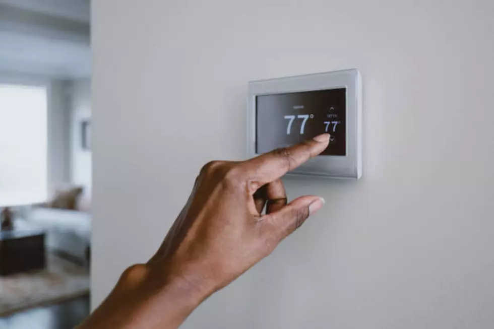 Close-up of unrecognizable black woman adjusting thermostat