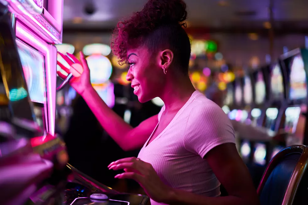 happy woman gambling at casino playing slot machine having lots of fun