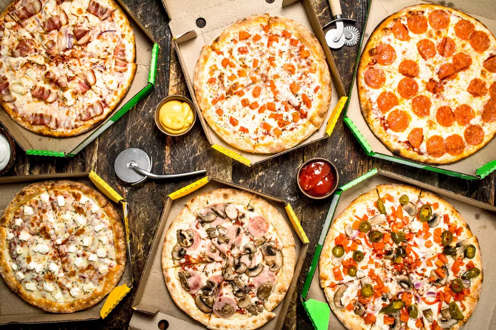 Fresh pizza in boxes. On a wooden background.