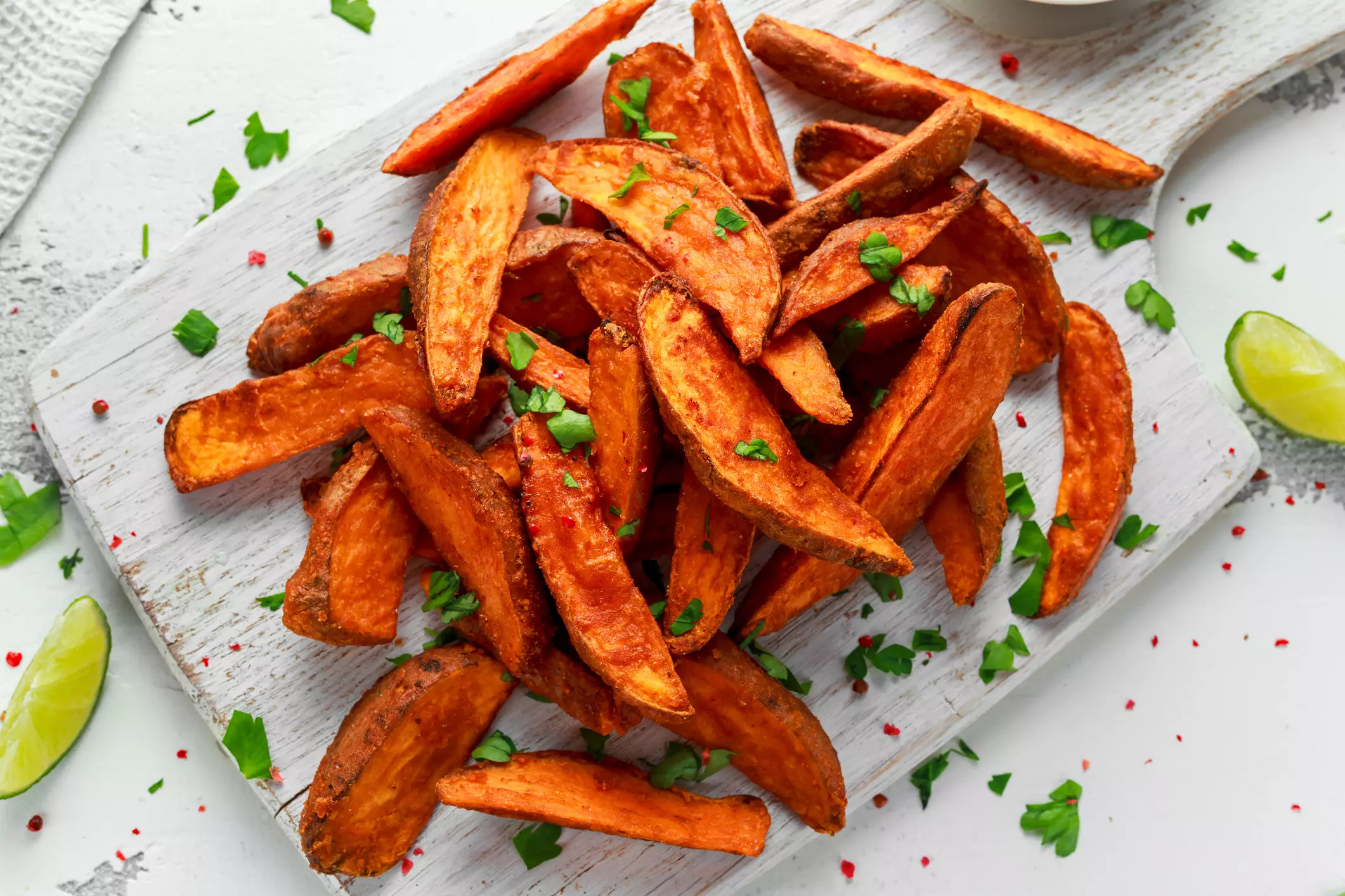 Healthy Homemade Baked Orange Sweet Potato wedges with fresh cream dip sauce, herbs, salt and pepper